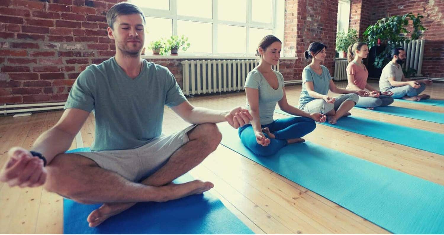 mediterende mensen met blauwe yoga matten