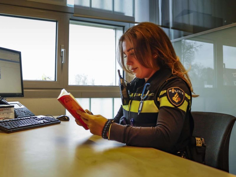 Politie agente boek lezen aan bureau (1)