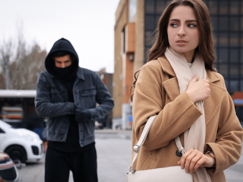 vrouw wordt op straat achtervolgt door man met donkere hoodie